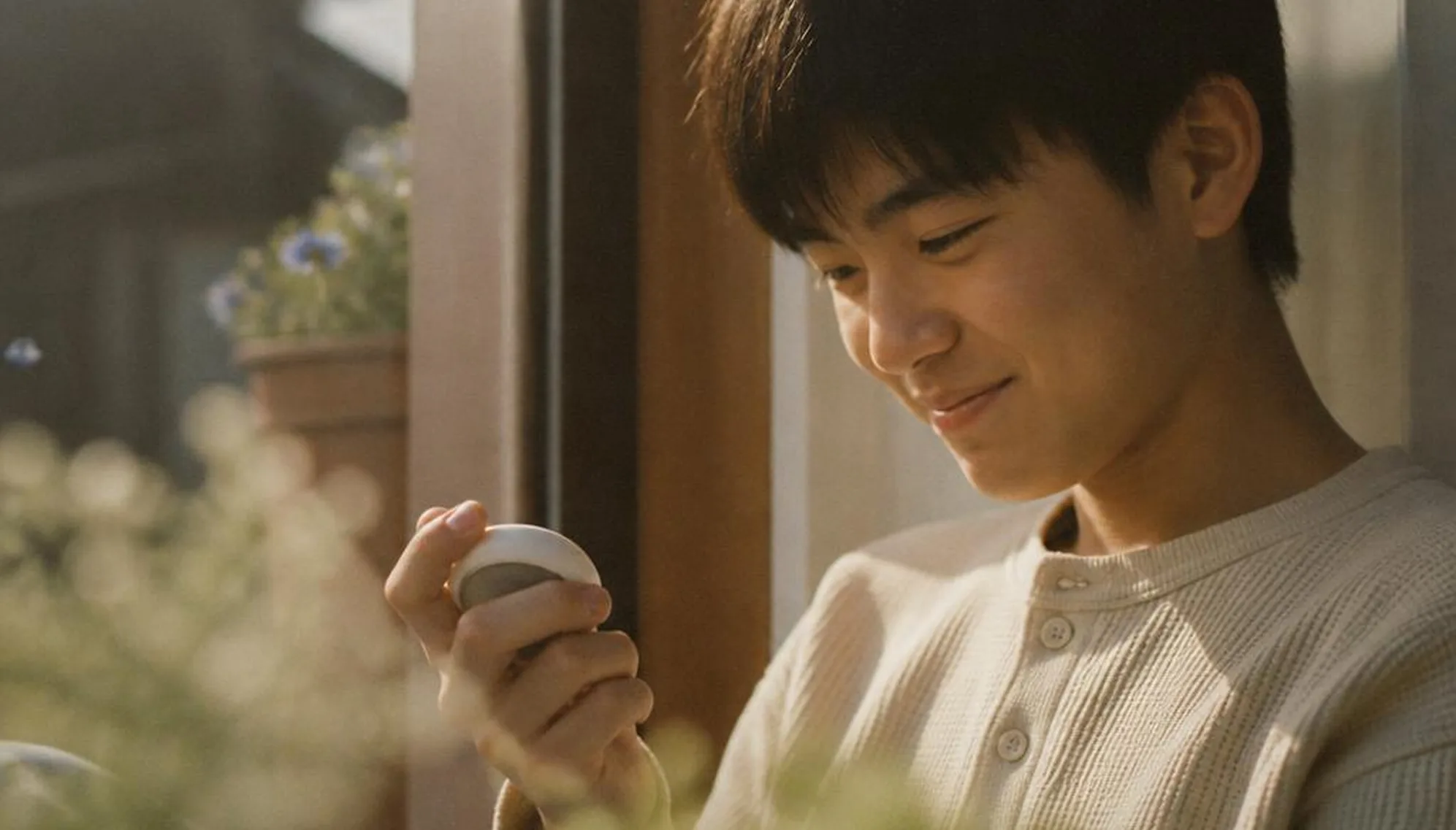 The softly lit portrait holding the device by a window.
