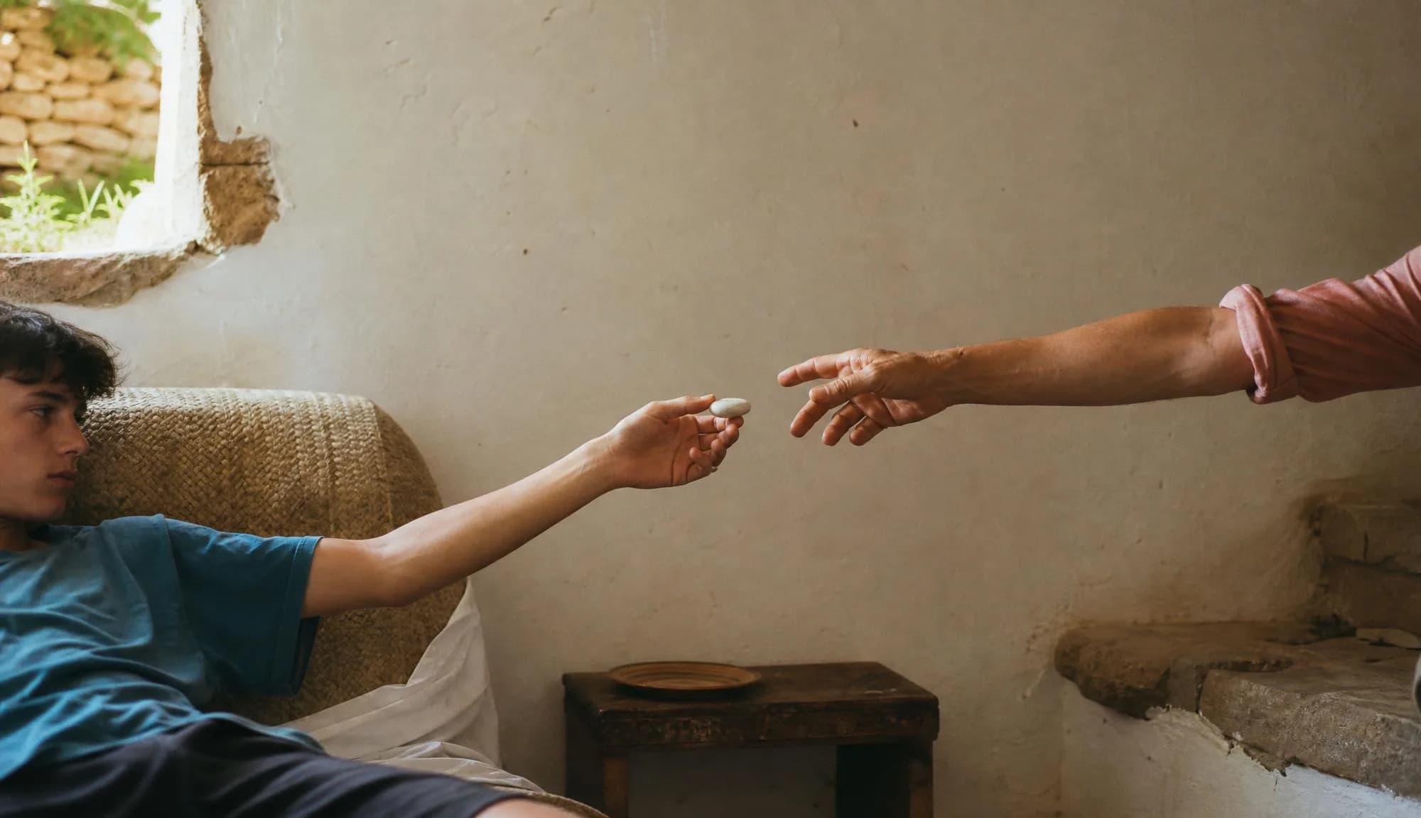 The outstretched hands passing the device.